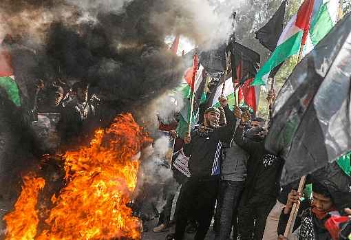 Com bandeiras palestinas, moradores da Cidade de Gaza queimam pneus, durante protesto contra o plano da Casa Branca