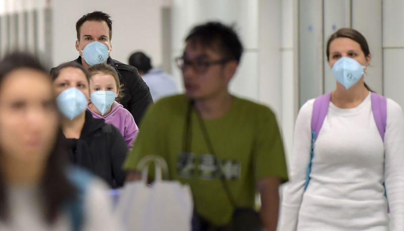 Passageiros usam mÃ¡scaras no aeroporto de Guarulhos (SP): estado lidera ranking da casos suspeitos no Brasil