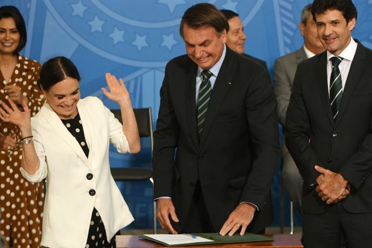 Regina Duarte e Bolsonaro olham o termo de posse durante cerimÃ´nia no Planalto: casamento polÃ­tico apÃ³s um namoro que comeÃ§ou em janeiro