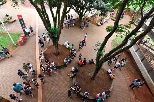 Foto do campus da Unicamp com alunos se preparando para realizar vestibular.