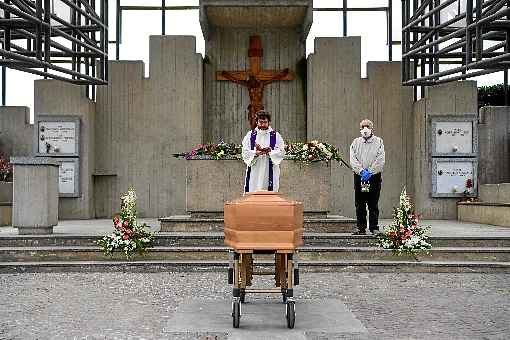 No cemitÃ©rio de Grassobbio, regiÃ£o da Lombardia, padre realiza ritos funerÃ¡rios diante de caixÃ£o: em quarentena, familiares de vÃ­tima se ausentaram