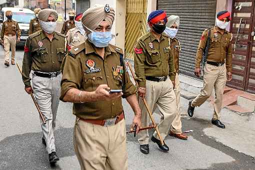 Policiais patrulham rua da cidade de Amritsar, no estado do Punjab, a poucas horas do inÃ­cio do isolamento