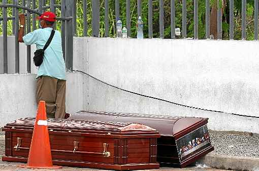 Com mÃ¡scara, equatoriano aguarda a liberaÃ§Ã£o de cadÃ¡ver, diante de caixÃµes deixados no meio da rua: novo coronavÃ­rus matou ao menos 120 no paÃ­s