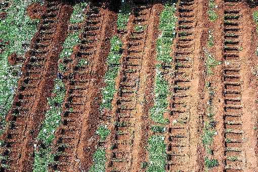 Dezenas de covas abertas em Vila Formosa, em SÃ£o Paulo, e trabalhadores do cemitÃ©rio: pandemia mudou a rotina dos campos e das cerimÃ´nias de despedida