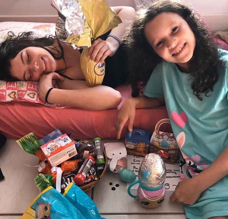 Yasmin Nathair, 16, ajuda a mÃ£e com os preparativos para a irmÃ£, Nicole, 9, procurar os ovos pela casa