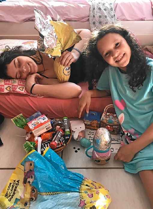 Yasmin Nathair, 16, ajuda a mÃ£e com os preparativos para a irmÃ£, Nicole, 9, procurar os ovos pela casa