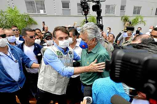 De mÃ¡scara, Bolsonaro e Caiado se abraÃ§am durante a visita do presidente ao hospital de Ãguas Lindas; o governador evitou criticar o presidente: 