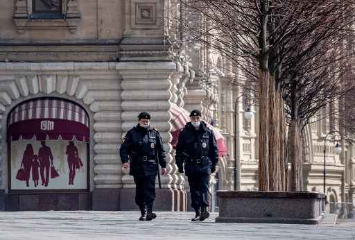 Dois policiais caminham usando mÃ¡scaras no centro de Moscou, RÃºssia.