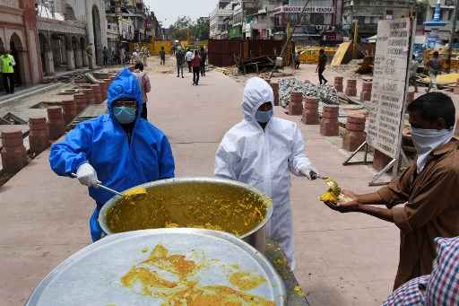 VoluntÃ¡rios distribuem comida para os sem teto na Ãndia durante a quarentena imposta pelo governo como medida preventiva para nÃ£o espalhar o coronavÃ­rus.