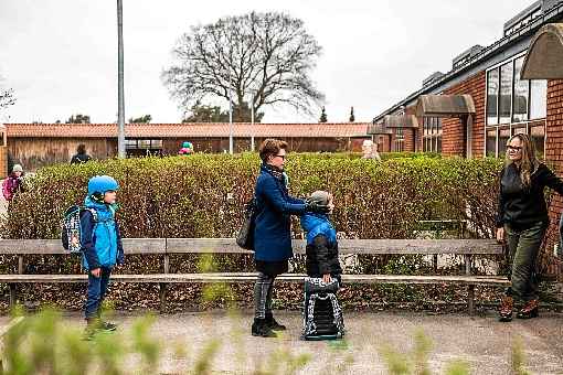 MÃ£e e filho aguardam em fila para entrar na Escola Stengard, ao norte de Copenhague, capital dinamarquesa: estabelecimentos terÃ£o de adotar atenÃ§Ã£o ao recreio e ao transporte dos alunos