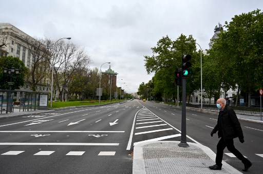 Homem atravessa a rua usando mÃ¡scara na Espanha