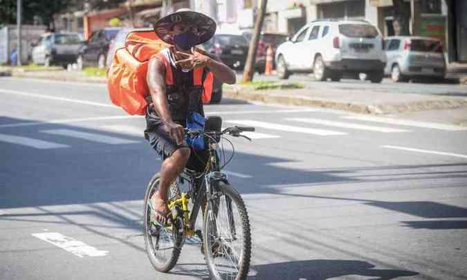 Entregador usa mÃ¡scara enquanto se desloca de bicicleta pela cidade