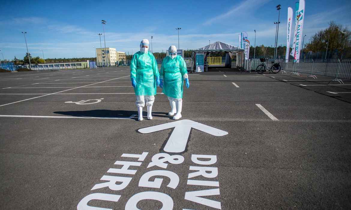 MÃ©dicos em um estacionamento com uma seta no chÃ£o apontada pra eles.