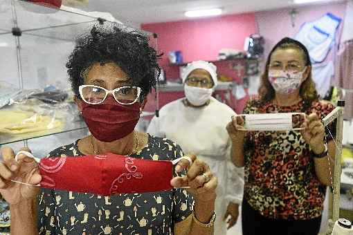 Com as colegas, Maria JosÃ© Nunes (centro) vende mÃ¡scaras estlizadas de proteÃ§Ã£o contra o coronavÃ­rus