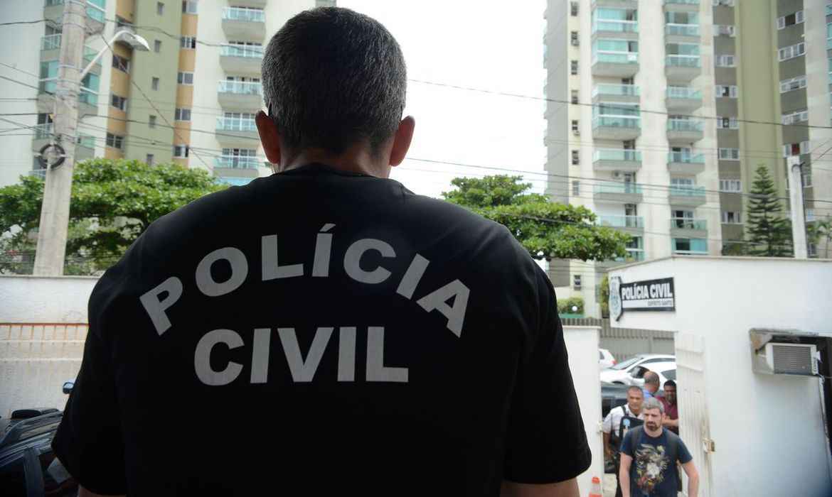 Homem de costas com uniforme da Policia Civil