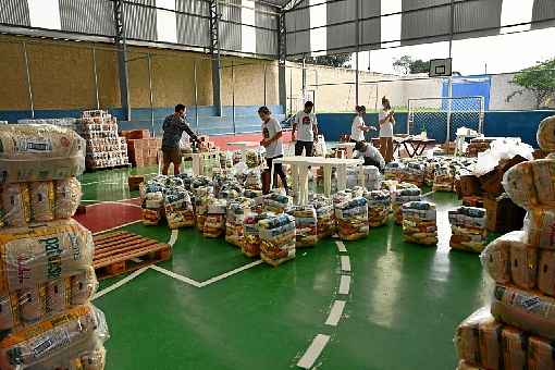 Em quadra de esporte de uma escola de Alto ParaÃ­so, voluntÃ¡rios montaram os kits de mantimentos para a populaÃ§Ã£o