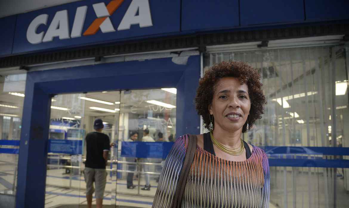 Mulher em frente a agÃªncia da Caixa.