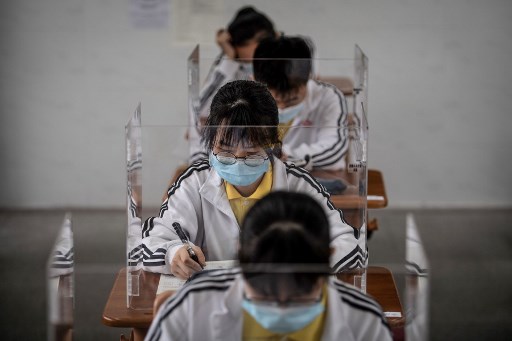 Alunos do Ãºltimo ano do ensino mÃ©dio estudam com partiÃ§Ãµes plÃ¡sticas em uma sala de aula em Wuhan, na provÃ­ncia central de Hubei, na China, em 6 de maio de 2020.