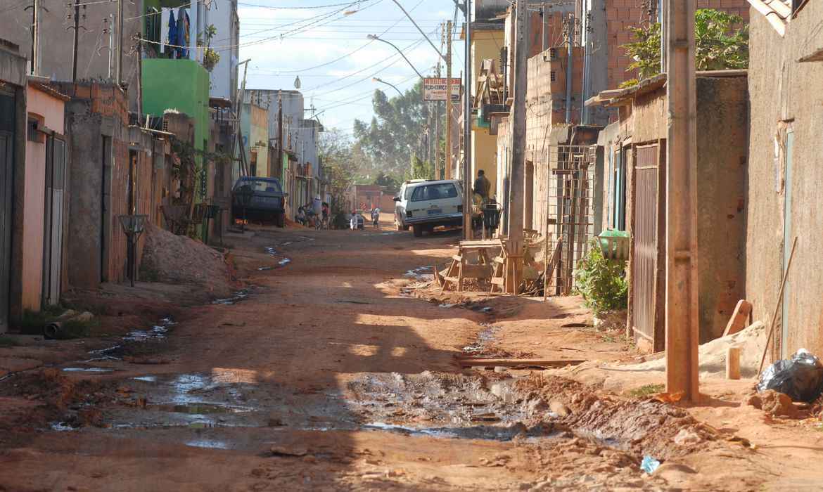 Rua de casas com barro e sem asfalto.