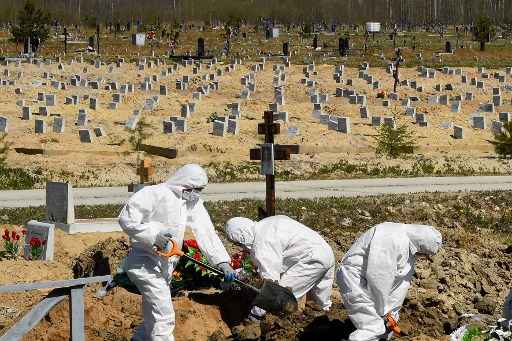 Trabalhadores do cemitÃ©rio usando equipamento de proteÃ§Ã£o enterram uma vÃ­tima de coronavÃ­rus em um cemitÃ©rio nos arredores de SÃ£o Petersburgo.