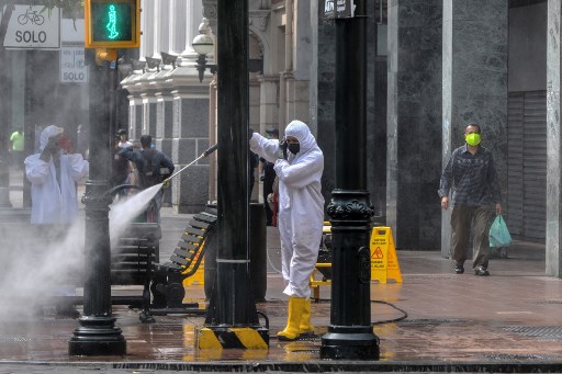 Trabalhadores municipais desinfetam as ruas em Guayaquil, Equador.