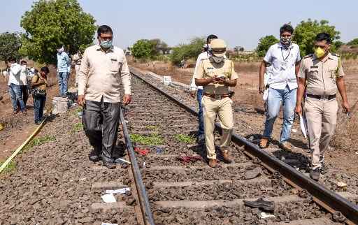 O pessoal da polÃ­cia e os oficiais andam em uma via fÃ©rrea enquanto verificam o local apÃ³s um acidente de trem com trabalhadores migrantes dormindo na ferrovia entre os distritos de Jalna e Aurangabad no estado de Maharashtra nesta sexta-feira.