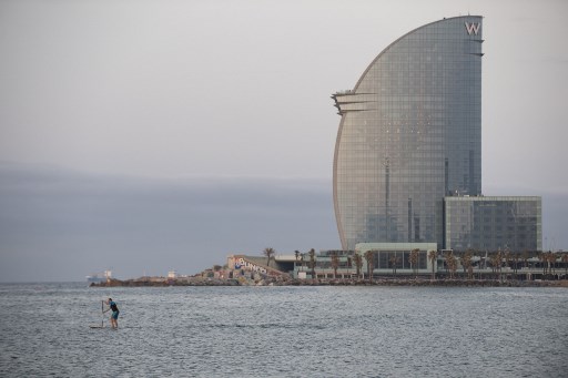 Um homem pratica paddle surf na praia de La Barceloneta em Barcelona, %u200B%u200Bem 8 de maio de 2020, aberto pela primeira vez desde que a Espanha declarou estado de emergÃªncia devido ao novo surto de coronavÃ­rus.