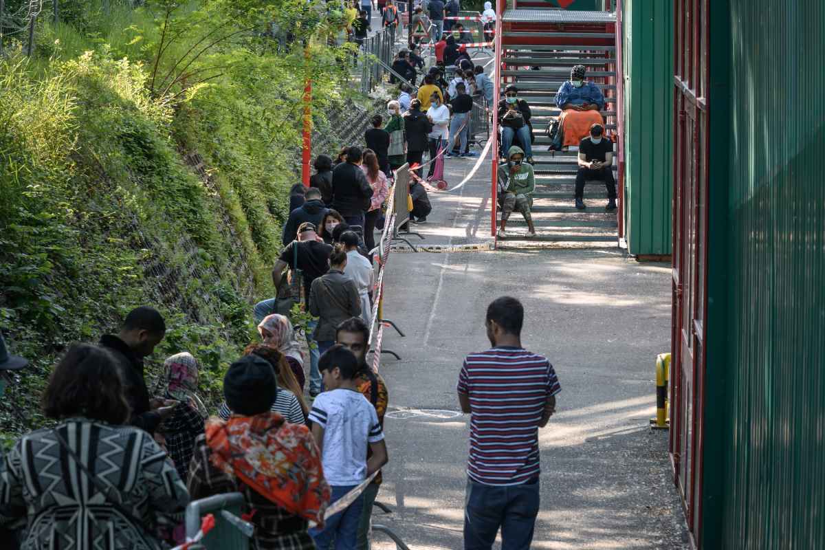 Pessoas em necessidade fazem fila na distribuiÃ§Ã£o gratuita de alimentos