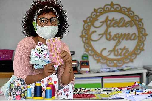 A artesÃ£ Claudia Martins confecciona mÃ¡scaras para venda e segue as orientaÃ§Ãµes de saÃºde das autoridades: cuidado na produÃ§Ã£o