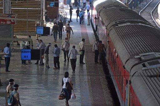 Passageiros e pessoal de seguranÃ§a estÃ£o na plataforma da estaÃ§Ã£o ferroviÃ¡ria central de Mumbai em 12 de maio de 2020, antes da partida do trem para Nova DÃ©lhi.