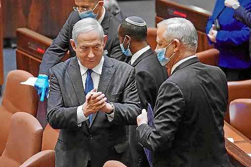 Benjamin Netanyahu (E) e Benny Gantz conversam na Knesset (Parlamento), pouco antes do juramento