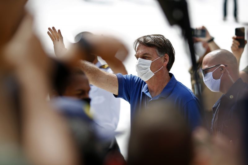 Bolsonaro acenando de mascara