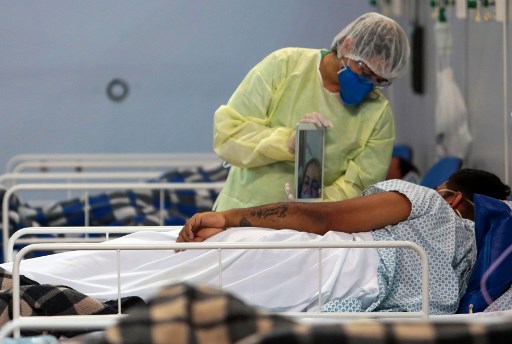 Um paciente afetado pelo coronavÃ­rus COVID-19 fala com um membro da famÃ­lia por uma videochamada em um hospital de campo instalado em uma academia de esportes, em Santo AndrÃ©, estado de SÃ£o Paulo, Brasil, em 11 de maio de 2020.