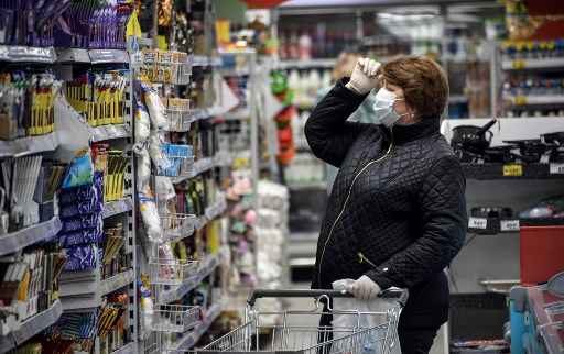 Uma mulher usando mÃ¡scaras protetoras compra em um supermercado em Moscou em 13 de maio de 2020