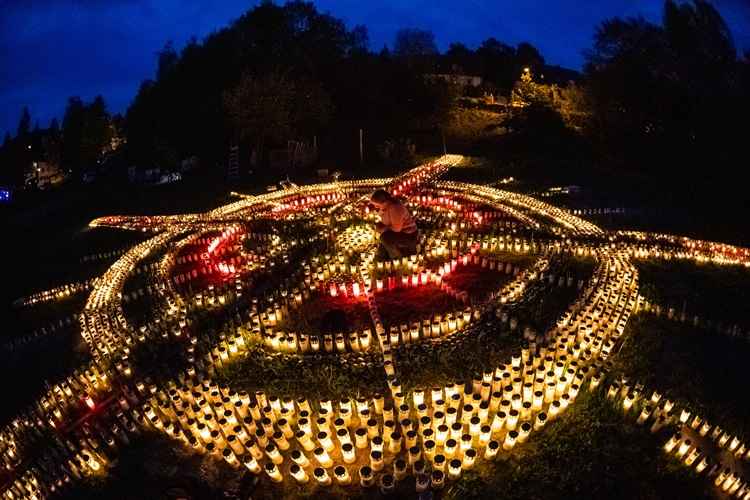 Arrumadas em formato de cruz, as velas pretendem homenagear as pessoas mortas pela covid-19. Cada uma representa um dos 8 mil mortos registrados no paÃ­s desde marÃ§o