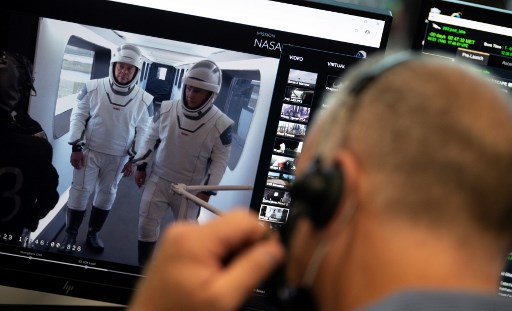 Esta foto divulgada pela NASA mostra os astronautas da NASA Robert Behnken, Ã  esquerda, e Douglas Hurley, Ã  direita, sÃ£o vistos em um monitor mostrando o braÃ§o de acesso da tripulaÃ§Ã£o no Launch Complex 39