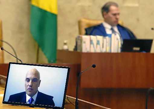 Alexandre de Moraes (na tela do computador) e Dias Toffoli (ao fundo): Supremo enfrenta forte reaÃ§Ã£o polÃ­tica em razÃ£o de inquÃ©rito que apura ameaÃ§a aos ministros