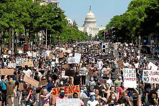 Milhares de pessoas ocupam ruas em Washington, com cartazes mostrando frases como 