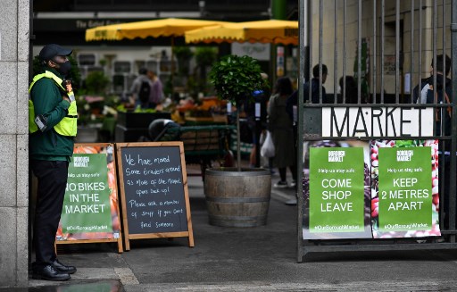 Sinais que promovem o distanciamento social sÃ£o mostrados na entrada do Borough Market, em Londres, em 6 de junho de 2020, quando as medidas de bloqueio sÃ£o parcialmente aliviadas durante a nova pandemia de coronavÃ­rus covid-19.