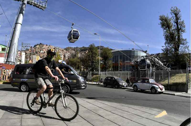 Homem de mÃ¡scara anda em de bicicleta em rua de El Alto, na BolÃ­via