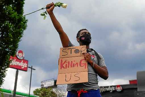 Protesto no local do assassinato: rosa e placa com a mensagem %u201CParem de nos matar%u201D