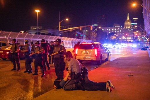 Um manifestante Ã© detido depois que algumas dezenas de manifestantes caminharam em uma ponte bloqueada pela polÃ­cia em 14 de junho de 2020 em Atlanta, GeÃ³rgia.