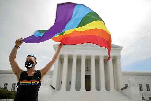 Com a bandeira do arco-Ã­ris nas mÃ£os, ativista celebra o resultado, em frente ao tribunal, em Washington: lei de 1964 foi invocada pelos magistrados