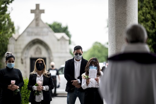 Fabian Arias (R), pastor luterano da Igreja de SÃ£o Pedro em Manhattan, celebra um funeral com a famÃ­lia de Francia Nelly, uma mulher do Equador que morreu de complicaÃ§Ãµes relacionadas ao novo coronavÃ­rus (COVID-19), no St. John CemitÃ©rio no Queens em 5 de junho de 2020 na cidade de Nova York.