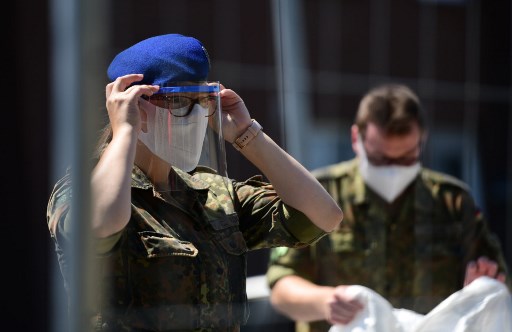 Soldados de uma unidade mÃ³vel de testes da Cruz Vermelha AlemÃ£ e do exÃ©rcito alemÃ£o (Bundeswehr) se preparam para coletar os testes Covid-19 de funcionÃ¡rios da Toennies Abatoir, em suas casas residenciais em Verl, oeste da Alemanha.