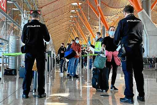 Policiais espanhÃ³is conferem documentos de passageiros apÃ³s desembarque no aeroporto de Madri: Europa realiza abertura lenta para conter doenÃ§a