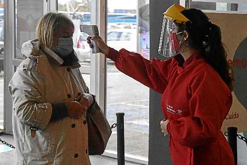 FuncionÃ¡ria de shopping de MontevidÃ©u monitora temperatura de cliente