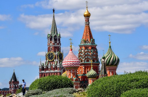 Um policial patrulha no parque Zaryadye com a torre Spasskaya do Kremlin e a Catedral de SÃ£o BasÃ­lio em segundo plano no centro de Moscou em 29 de junho de 2020.