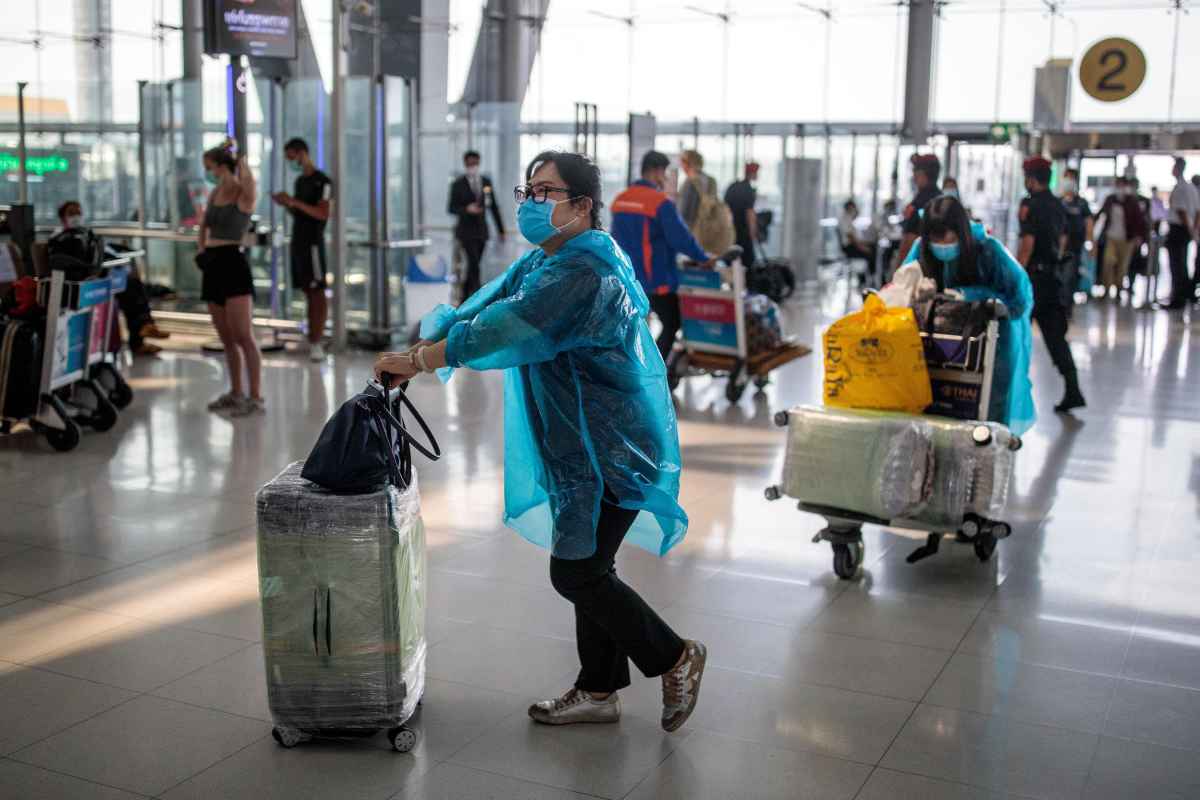 Pessoas de mÃ¡scara no aeroporto