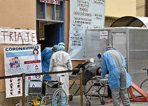 FuncionÃ¡rios de hospital carregam corpo de vÃ­tima da covid-19, em La Paz